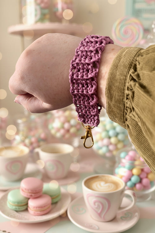 Crochet wrist strap in dusty purple worn on wrist with gold lobster clasp